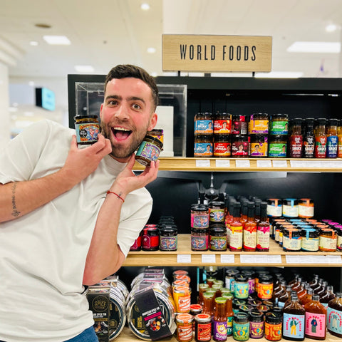 Yep Kitchen founder Tom Palmer holding jars of Yep Kitchen chilli oil in Selfridges